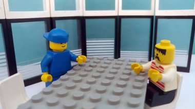 İki lego bir konferans odasında oturup konuşuyor.