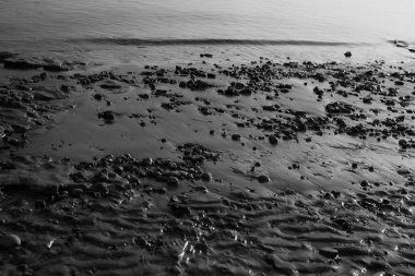 Su dokusuna yakın çekim, kıyıdaki pürüzsüz su dalgaları, suyun manzara fotoğrafı.