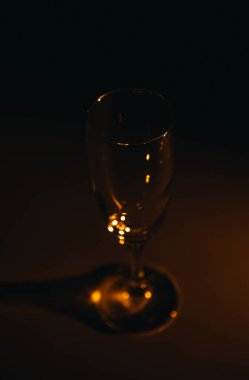 Karanlık bir arka planda şampanya bardağının silüeti.