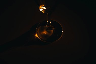 Karanlık bir arka planda şampanya bardağının silüeti.