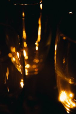 Birkaç şampanya kadehinden oluşan bir grup, koyu bir arka plan karşısında güzelce aydınlatılıyor. Şenlikli bir kompozisyon. Metin için boşluk