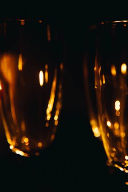 Birkaç şampanya kadehinden oluşan bir grup, koyu bir arka plan karşısında güzelce aydınlatılıyor. Şenlikli bir kompozisyon. Metin için boşluk