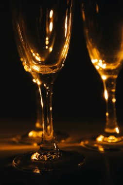 Birkaç şampanya kadehinden oluşan bir grup, koyu bir arka plan karşısında güzelce aydınlatılıyor. Şenlikli bir kompozisyon. Metin için boşluk
