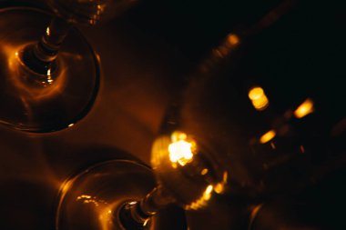 Birkaç şampanya kadehinden oluşan bir grup, koyu bir arka plan karşısında güzelce aydınlatılıyor. Şenlikli bir kompozisyon. Metin için boşluk