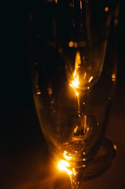 Birkaç şampanya kadehinden oluşan bir grup, koyu bir arka plan karşısında güzelce aydınlatılıyor. Şenlikli bir kompozisyon. Metin için boşluk