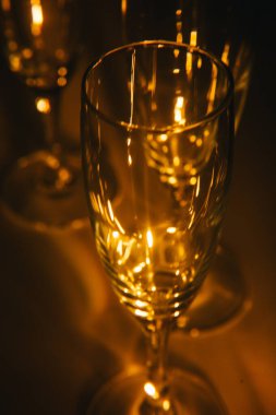 Birkaç şampanya kadehinden oluşan bir grup, koyu bir arka plan karşısında güzelce aydınlatılıyor. Şenlikli bir kompozisyon. Metin için boşluk
