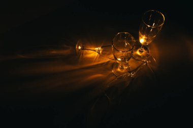 Birkaç şampanya kadehinden oluşan bir grup, koyu bir arka plan karşısında güzelce aydınlatılıyor. Şenlikli bir kompozisyon. Metin için boşluk