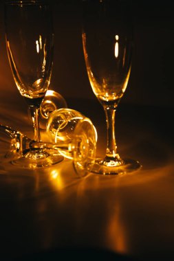 Birkaç şampanya kadehinden oluşan bir grup, koyu bir arka plan karşısında güzelce aydınlatılıyor. Şenlikli bir kompozisyon. Metin için boşluk