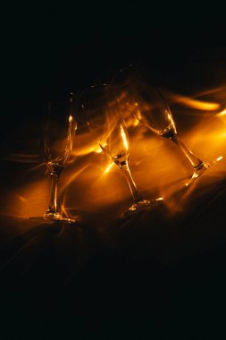 Birkaç şampanya kadehinden oluşan bir grup, koyu bir arka plan karşısında güzelce aydınlatılıyor. Şenlikli bir kompozisyon. Metin için boşluk