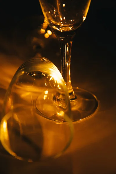 暗めの背景にオレンジのライトがついているワイングラスが2つ シルエットと構図の幾何学 テキストのスペース — ストック写真