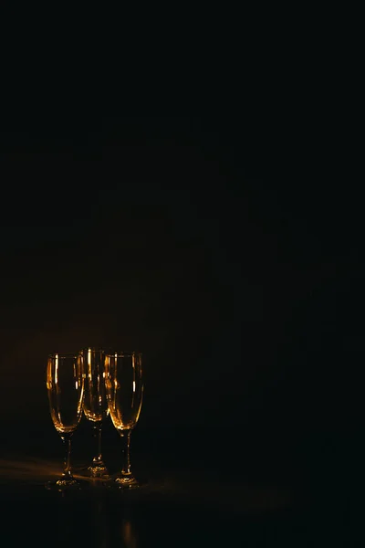 一组几只香槟酒杯在黑暗的背景下闪闪发亮 一个节日的作文 案文的篇幅 — 图库照片