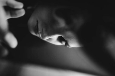 Siyah beyaz bir resim, bir kız aynaya bakar ve yansımasını görür.