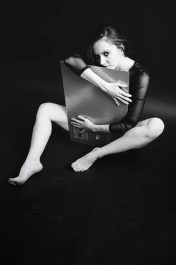 Siyah beyaz bir resim, bir kız aynaya bakar ve yansımasını görür.