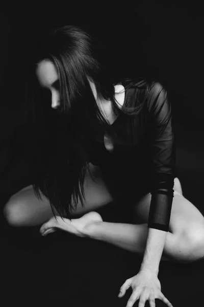 时尚时尚的照片 黑白照片中的一个穿着紧身衣的女孩 女孩在黑暗的背景下在演播室里自由地跳舞和走动 在镜头前摆姿势 — 图库照片