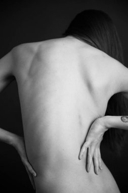 Vücut parçalarının siyah beyaz fotoğrafı. Geometri ve yoga pozları, arka planda çıplak bir kadın vücudu. Metin için boşluk