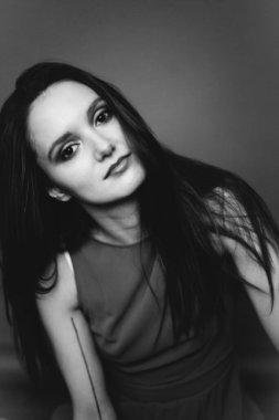 Stüdyoda esmer bir kızın siyah-beyaz portresi, genç bir kadının yüzünde duygular, çeşitli yakın plan portreler ve el hareketleri.