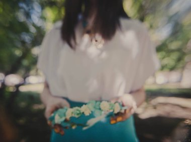 wreath of flowers in close-up, a beautiful decoration on the head in the hands of a girl