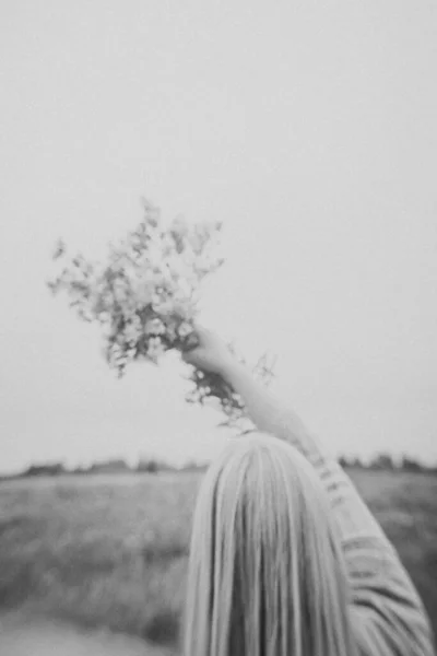 野の花を持つ少女が畑を歩き — ストック写真