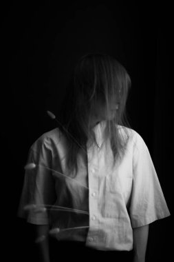 İnsanlar ve kuru bitkiler. Bir kızın minimalist siyah beyaz portresi ve bir bitki. Metin için boşluk