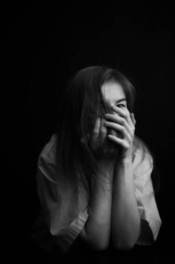 Bir kızın siyah beyaz stüdyo portresi. Güzel bir kadının yüzündeki duygular, yüz ifadeleri ve el hareketleri, aktörün plastik yakın çekimi..