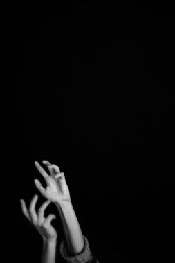 Cesedin detayları, elleri siyah arkaplanda yakın plan.