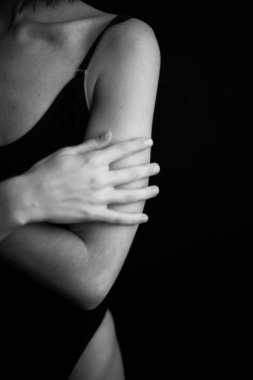 Cesedin detayları, elleri siyah arkaplanda yakın plan.