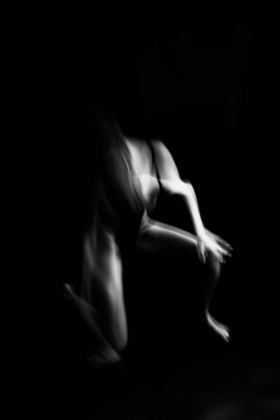 Art photography, dancer expresses emotions through movement, body abstraction on black background
