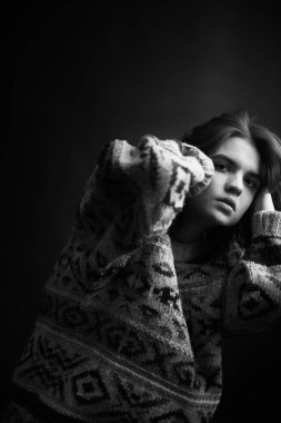 Genç bir kızın yüzünde hüzün ve hayal kırıklığı vardı. Stüdyodaki karanlık bir arka planda yüz ifadelerinin siyah-beyaz otantik portresi.