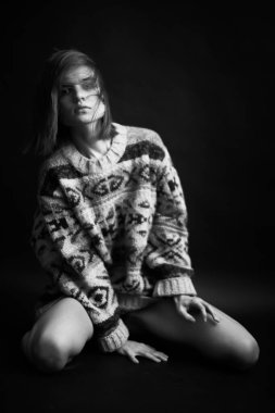 Genç bir kızın yüzünde hüzün ve hayal kırıklığı vardı. Stüdyodaki karanlık bir arka planda yüz ifadelerinin siyah-beyaz otantik portresi.