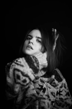 Genç bir kızın yüzünde hüzün ve hayal kırıklığı vardı. Stüdyodaki karanlık bir arka planda yüz ifadelerinin siyah-beyaz otantik portresi.