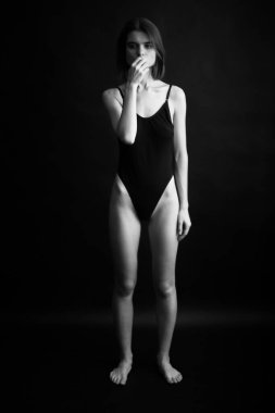 Genç bir kızın yüzünde hüzün ve hayal kırıklığı vardı. Stüdyodaki karanlık bir arka planda yüz ifadelerinin siyah-beyaz otantik portresi.