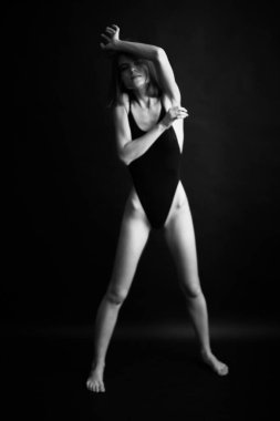 Genç bir kızın yüzünde hüzün ve hayal kırıklığı vardı. Stüdyodaki karanlık bir arka planda yüz ifadelerinin siyah-beyaz otantik portresi.