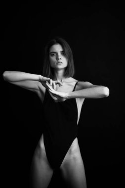 Genç bir kızın yüzünde hüzün ve hayal kırıklığı vardı. Stüdyodaki karanlık bir arka planda yüz ifadelerinin siyah-beyaz otantik portresi.