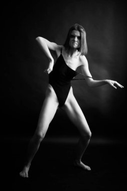 Genç bir kızın yüzünde hüzün ve hayal kırıklığı vardı. Stüdyodaki karanlık bir arka planda yüz ifadelerinin siyah-beyaz otantik portresi.