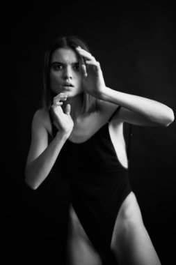 Genç bir kızın yüzünde hüzün ve hayal kırıklığı vardı. Stüdyodaki karanlık bir arka planda yüz ifadelerinin siyah-beyaz otantik portresi.