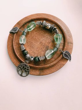 El yapımı bilezik, doğal taşlar ve kristaller, bileğinde mücevherler. Parçaların ve aksesuarların makro fotoğrafçılığı. Metin için boşluk.