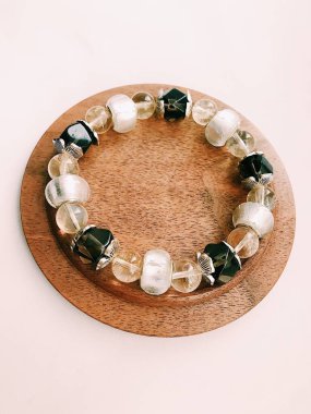 El yapımı bilezik, doğal taşlar ve kristaller, bileğinde mücevherler. Parçaların ve aksesuarların makro fotoğrafçılığı. Metin için boşluk.