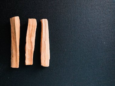 Palo Santo ağacının dağılmış dalları karanlık bir arka planda. Üst Manzara. Latin Amerika 'dan organik kutsal ağaç tütsüsü. Doğal tütsü renginde yakın plan fotoğraf.
