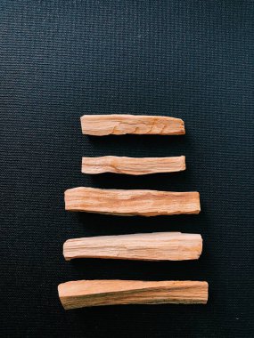 Palo Santo ağacının dağılmış dalları karanlık bir arka planda. Üst Manzara. Latin Amerika 'dan organik kutsal ağaç tütsüsü. Doğal tütsü renginde yakın plan fotoğraf.