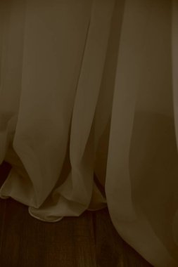 Beyaz şeffaf perdeler, içinde tül kumaş dokusu.