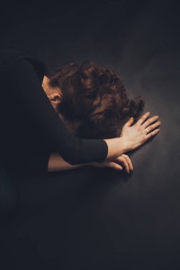 Siyah arka planda minimalist kıyafetler giymiş bir kızın dramatik portresi.