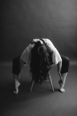 siyah beyaz basit bir kız portresi sandalyede oturuyor.