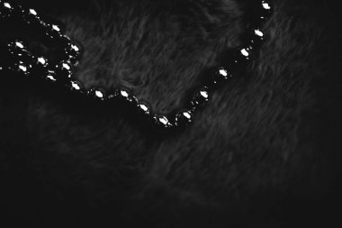 Noel kompozisyonu, yeni yıl konsepti. Koyu kürk arka planında güzel gümüş Noel boncukları. Düz konum, üst görünüm, kopyalama alanı