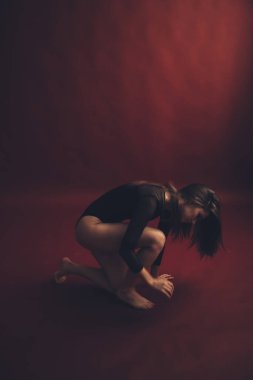 Kırmızı arka planda siyah dantelli vücutlu dansçı kızın soyut portresi. Bulanık film fotoğrafı