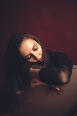 Kırmızı arka planda siyah dantelli vücutlu dansçı kızın soyut portresi. Bulanık film fotoğrafı