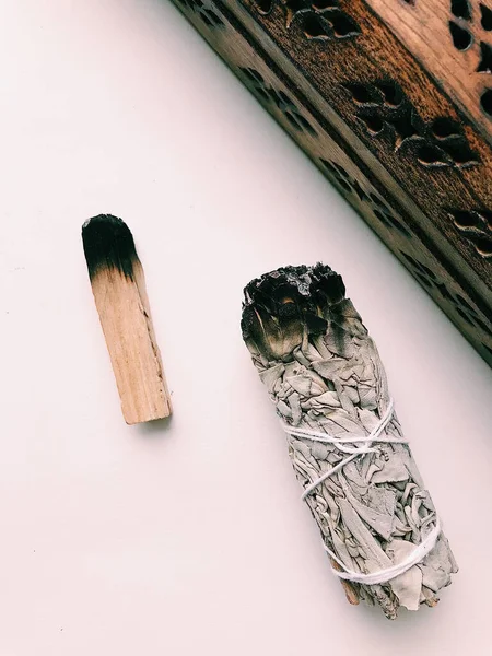 Natural incense White Sage and Palo Santo. Sacred tree of South America, color square photo.White Sage and Palo Santo on white background.