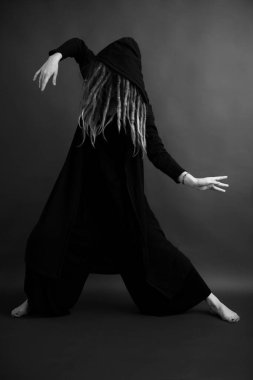 Siyah cüppeli, kapüşonlu, sanatsal fotoğraflı bir kız.