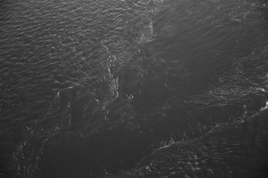 Okyanustaki yüksek ve alçak gelgitten sonra kumlu sahildeki desenler, siyah ve beyaz soyut kum arka planı