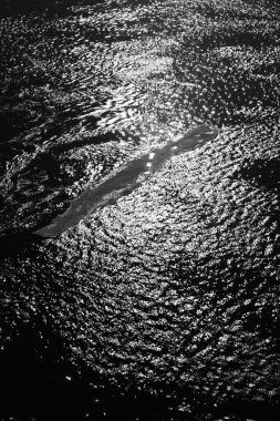 Okyanustaki yüksek ve alçak gelgitten sonra kumlu sahildeki desenler, siyah ve beyaz soyut kum arka planı