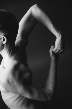 Yoga egzersizi. Adam karanlık arka planda yoga yapıyor. Stüdyo spor fotoğrafçılığı